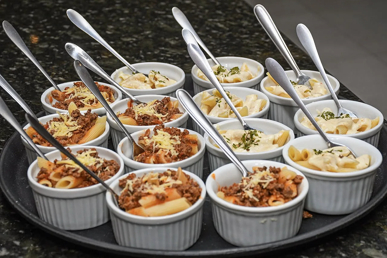 Ramequins individuais com penne à bolonhesa e massa ao molho branco, cada um com seu garfinho